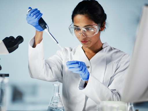 A scientist in a lab examining retinaldehyde and retinol under a microscope