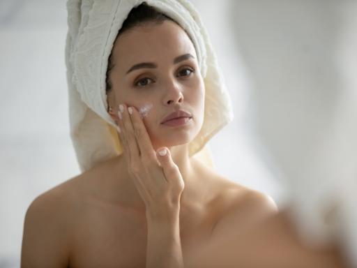 A woman applying a retinol product at night